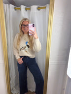 A woman wearing The Layla Sweater crafted from soft heathered knit fabric, features a relaxed fit ,crew neckline and long sleeves with a duck intarsia graphic at the front 