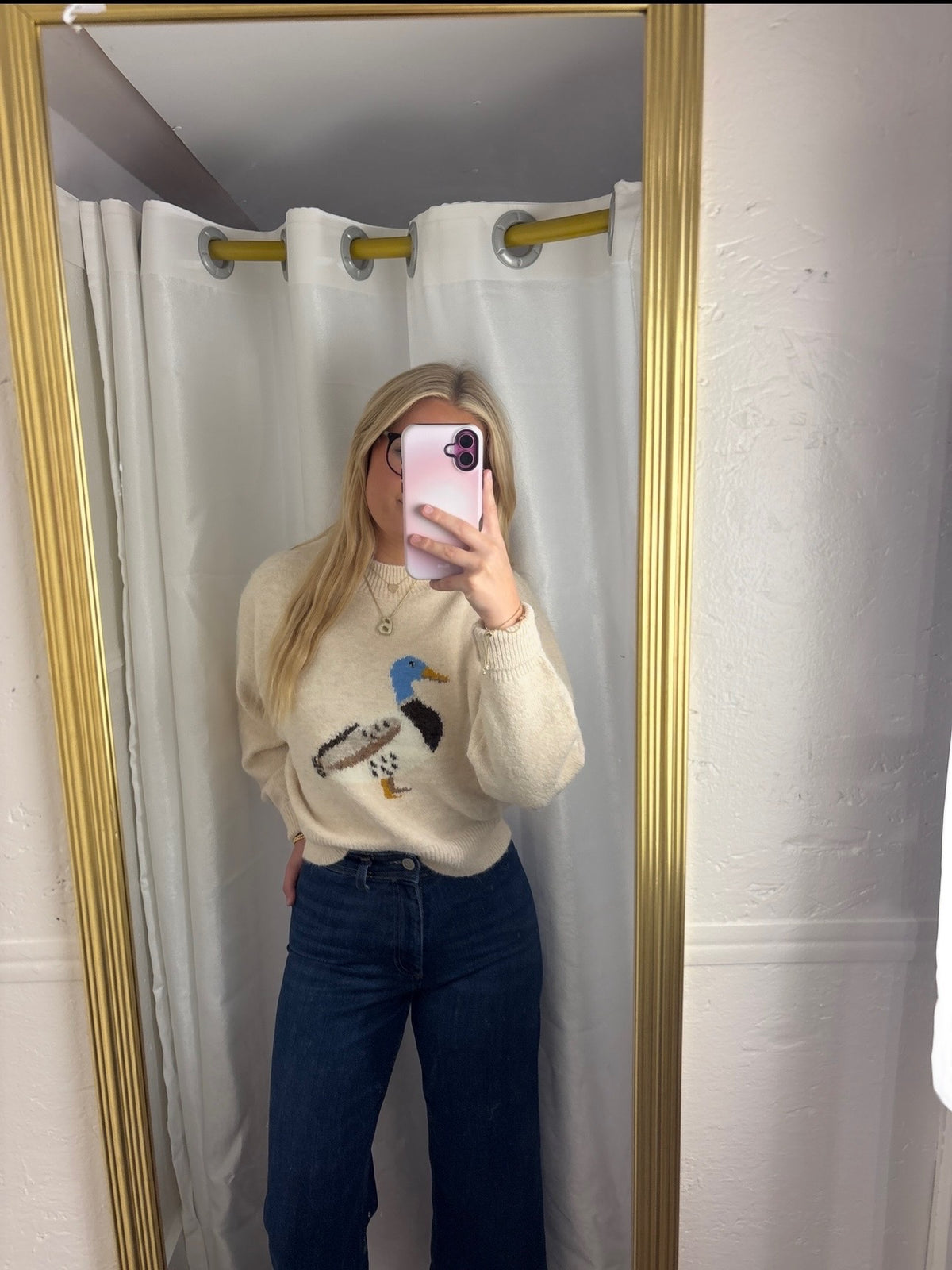 A woman wearing The Layla Sweater crafted from soft heathered knit fabric, features a relaxed fit ,crew neckline and long sleeves with a duck intarsia graphic at the front 