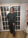 A woman wearing The Marlee Set that features a washed French terry round neck pullover paired with matching pants in a timeless black colorway