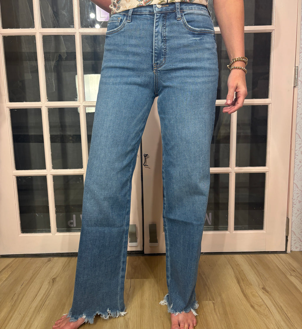 A woman wearing The Briana Jeans, featuring a super high rise waist and loose, vintage-inspired silhouette. Crafted from comfortable stretch denim in a medium wash.