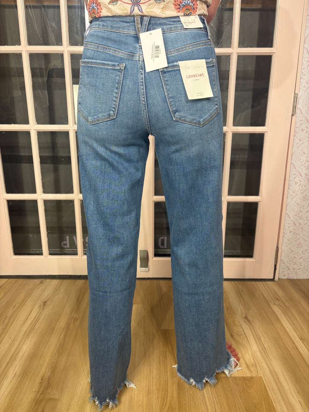 A woman wearing The Briana Jeans, featuring a super high rise waist and loose, vintage-inspired silhouette. Crafted from comfortable stretch denim in a medium wash.