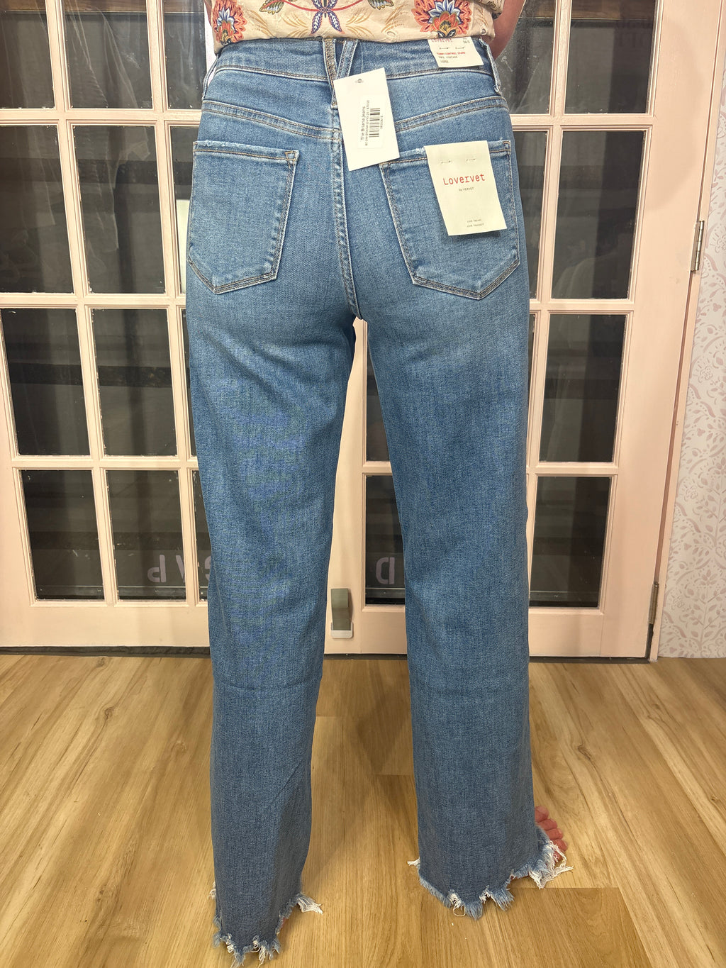 A woman wearing The Briana Jeans, featuring a super high rise waist and loose, vintage-inspired silhouette. Crafted from comfortable stretch denim in a medium wash.