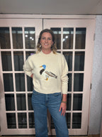 A woman wearing The Layla Sweater crafted from soft heathered knit fabric, features a relaxed fit ,crew neckline and long sleeves with a duck intarsia graphic at the front 