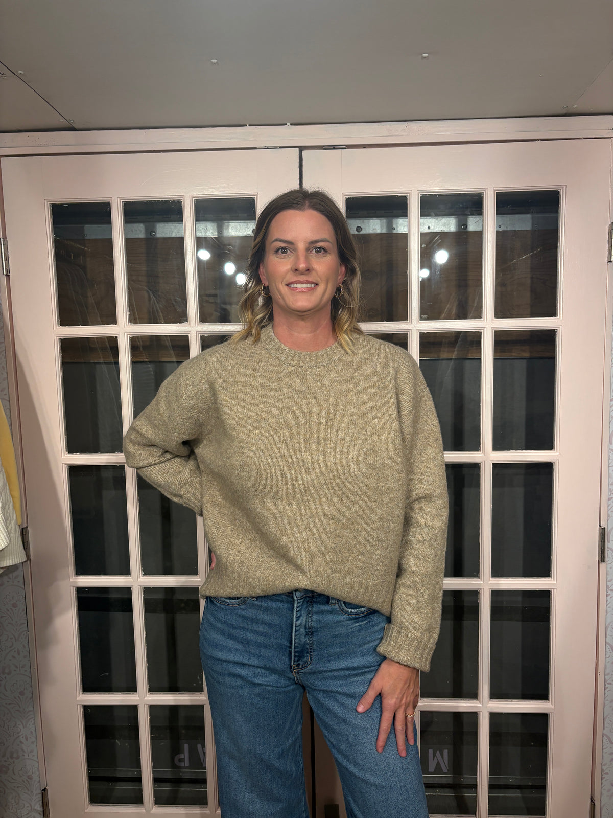 A woman wearing The Lennon Sweater that is a relaxed knit sweater with a soft brushed marled texture and crew neckline. Long sleeves, dropped shoulders, and wide ribbed trim at the cuffs and hem