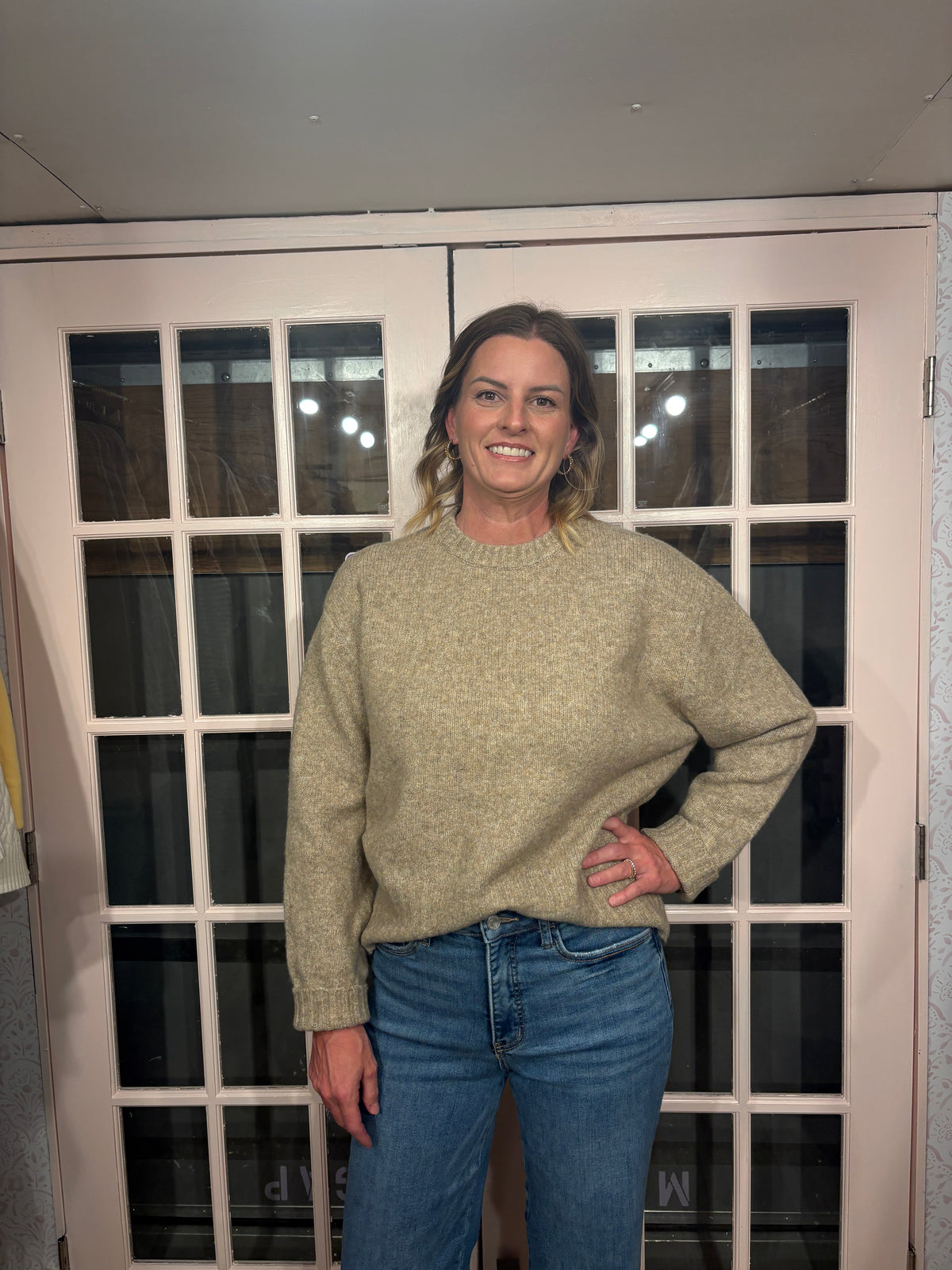 A woman wearing The Lennon Sweater that is a relaxed knit sweater with a soft brushed marled texture and crew neckline. Long sleeves, dropped shoulders, and wide ribbed trim at the cuffs and hem