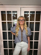 A woman wearing the Bri Blouse in brown and blue with a flattering V neckline, contrast trim, and statement puff sleeves