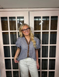 A woman wearing the Bri Blouse in brown and blue with a flattering V neckline, contrast trim, and statement puff sleeves