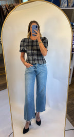 A woman wearing the Madilyn blouse in a blue plaid featuring a puff sleeve, button front and fitted silhouette