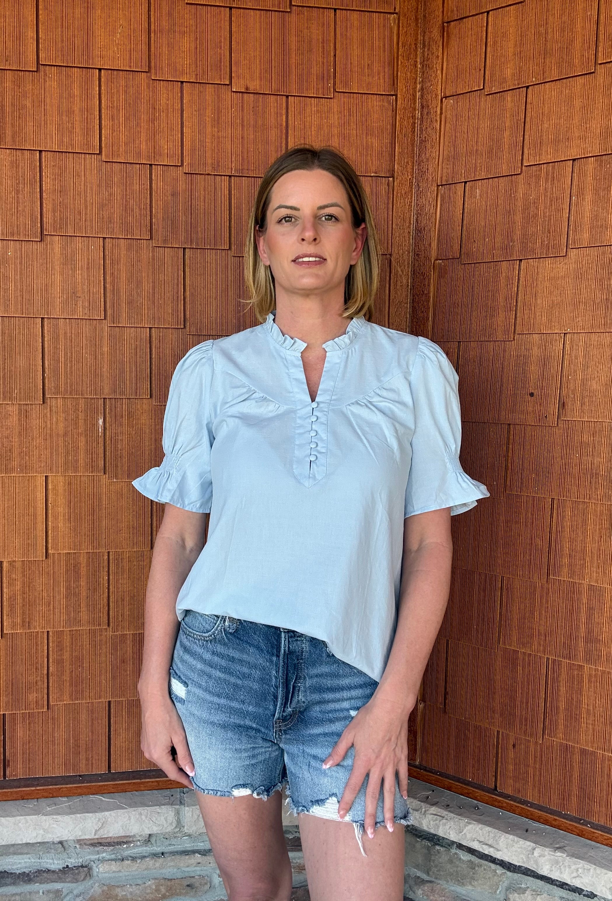 brooke & co soft skies top in light blue styled with denim shorts, relaxed everyday outfit front view