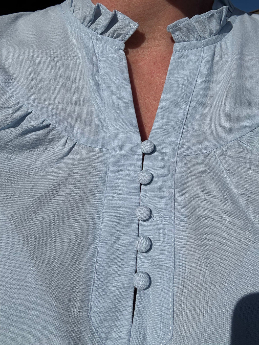 brooke & co soft skies top neckline detail in light blue featuring split neckline with button accents