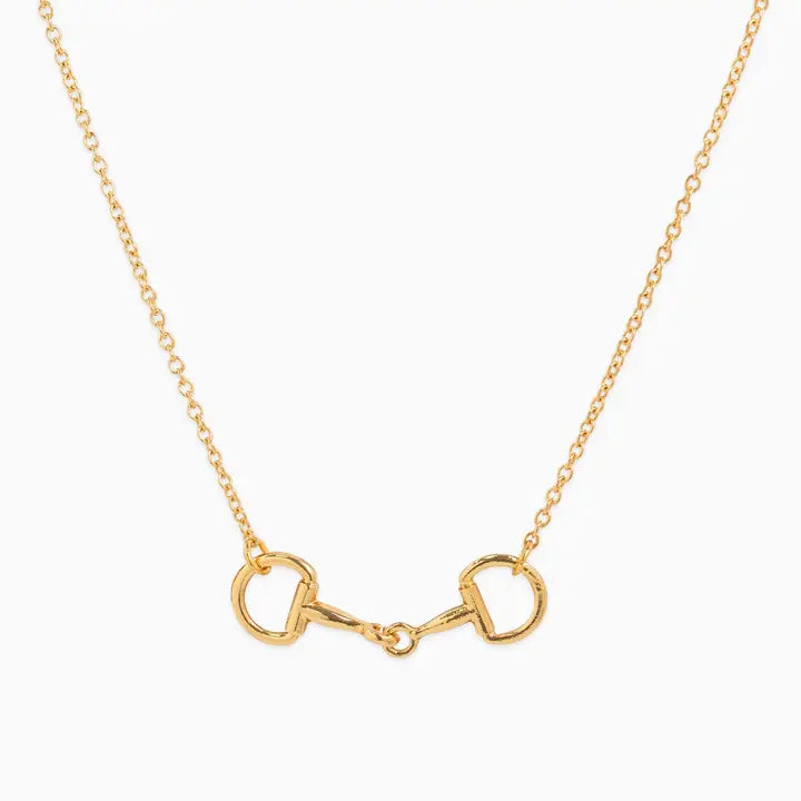 A gold horsebit necklace with a delicate cable chain, displayed against a clean white background.