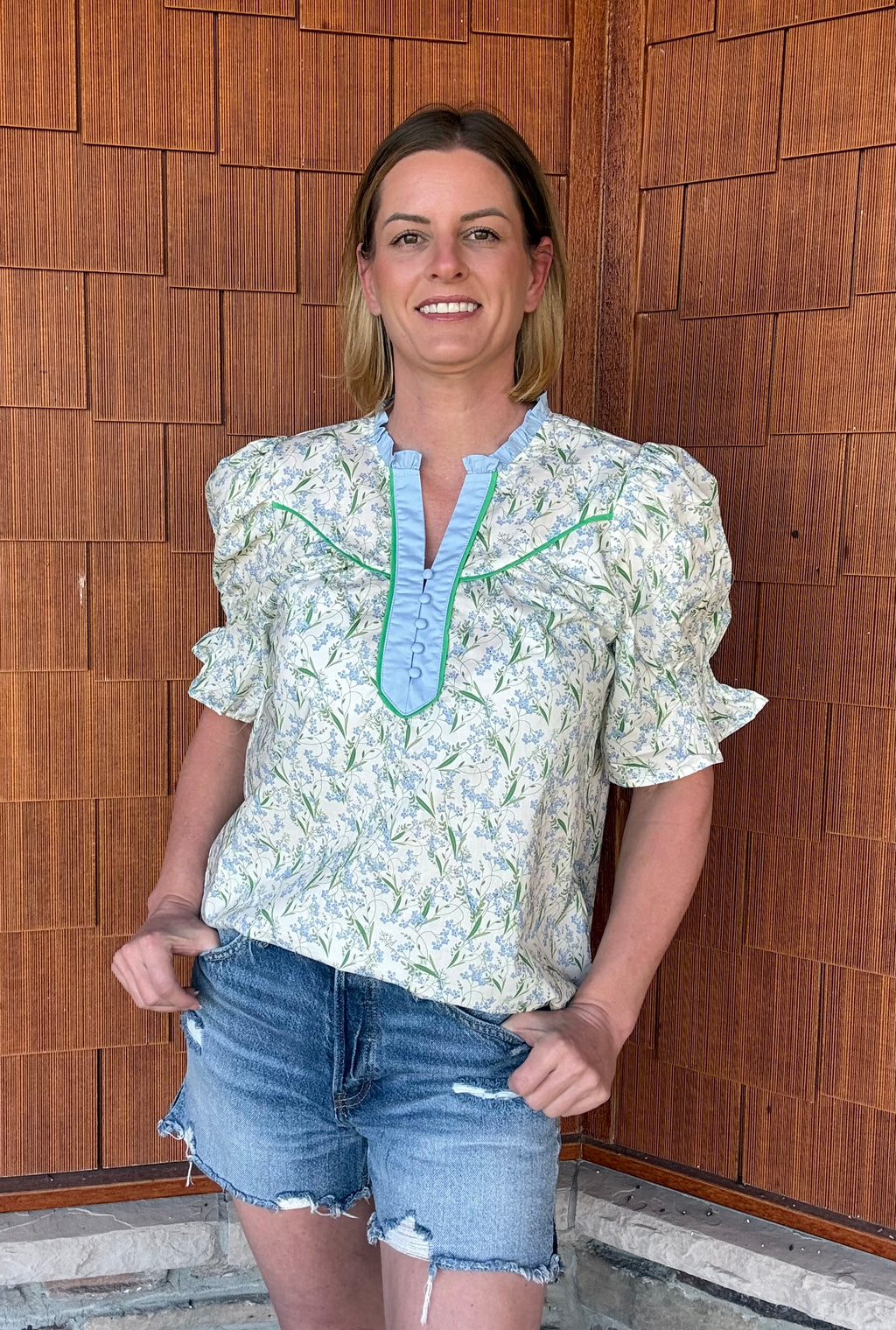 Brooke & Co spring meadow top in blue and green floral styled with denim shorts, everyday outfit front view