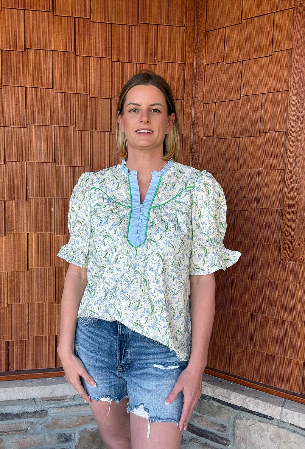 Brooke & Co blue and green floral spring meadow top full outfit view with denim shorts, easy casual styling